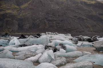The Solheimajokull Glacier in Iceland showing icebergs and calved ice in the lagoon as ice calves...
