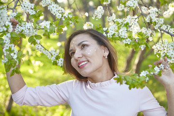 girl with flowers. gorgeous model in the spring garden. the girl near the tree in the spring.