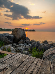 sunset at Franklin Beach Georgina Ontario Canada with nice trees, rocks, lake view, clouds, sun and wooden path