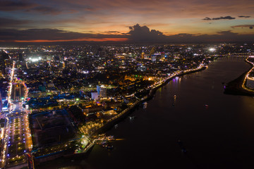 Fototapeta premium Top View of Building in a City - Aerial view Skyscrapers flying by drone of Phnom Penh city with riverside , Palace and small island in sunset