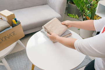 Woman preparing the old clothes she wants to donate for charity.