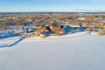 View of the frozen Vanajavesi  lake and the ancient fortress off Hameenlinna on a sunny March morning (aerial survey). Finland