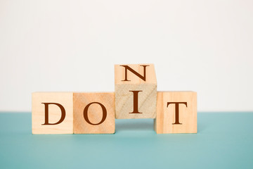 Flipping one wooden cube to change the word Don't for Do it on Isolated background.