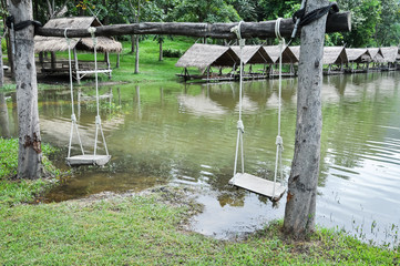 Wood swing with raft beside riverbank at Huay Tung Tao lake background in Chiang mai. Thailand