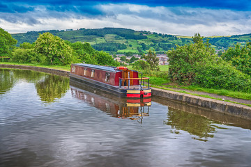 Narrowboat moored on a British canal in rural setting