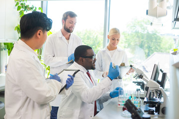Scientist and students working in lab. Doctor teaching interns to make blood analyzing research....