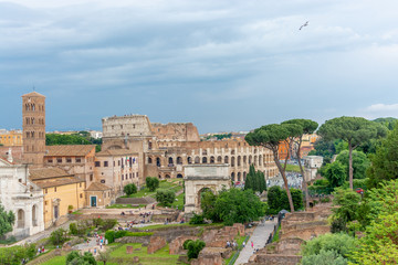 Roman forum during cloudy and rainy day with Colosseum background. Rome, Italy