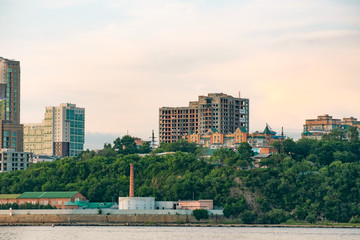 Fototapeta premium View of the city of Khabarovsk from the Amur river. Urban landscape in the evening at sunset.