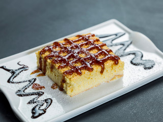 Tres leches dessert on plate over black table