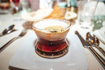 Appetizer served in a red bowl at a formal table