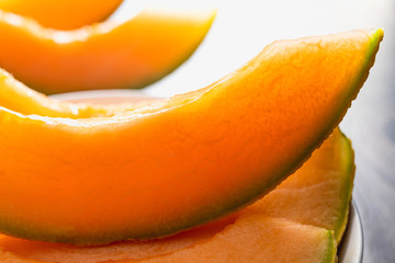 Cantaloupe Melon. Orange Cantaloupe Melon Slices on a Chopping Board Close Up on a Kitchen Table
