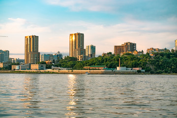 Obraz premium View of the city of Khabarovsk from the Amur river. Urban landscape in the evening at sunset.