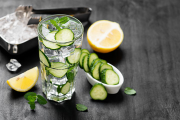 Healthy fresh cucumber lemonade with lemon and ice cubes.