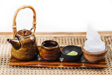 Vintage wooden brown tea set with fresh white towel in spa salon. Traditional ceremony.