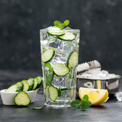 Healthy fresh cucumber lemonade with lemon and ice cubes.