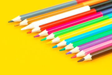 Multicolored pencil on yellow background