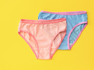 Red women's panties on blue on yellow background. The concept of meeting lovers. Underwear. The view from the top.