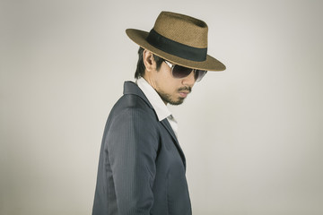 Portrait Man in Navy Blue Suit and Hat and Glasses on Right Pose Vintage Tone