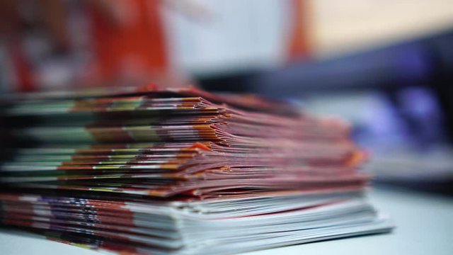 Business Brochure in Documents concept : Businessman hands working in stacks brochures paper files for checking document achieves reports on busy work desk office