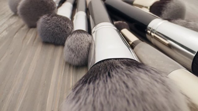 Cosmetics and beauty concept. Make-up brushes on wooden table