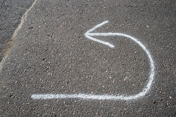 return arrow painted on tarmac