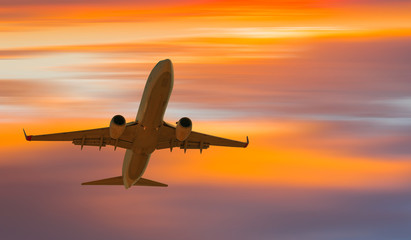 Passenger airplane in the clouds at sunset - Travel by air transport