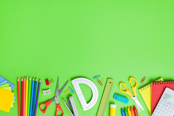 School supplies on green background. Back to school concept.
