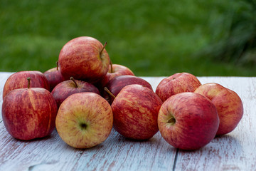 Organic ripe apples on a wooden table in the garden. Cooking ingredients. Harvest.