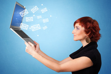 Woman holding laptop with online services symbols
