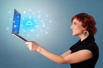 Woman holding laptop projecting notifications, symbols and information based on cloud technology system