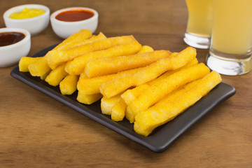Traditional Brazilian recipe fried polenta in wood background
