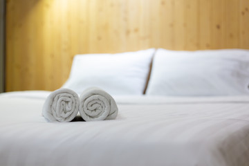 White towel on bed in guest room for hotel customer.
