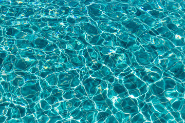 Background of rippled pattern of clean water in a blue swimming pool.