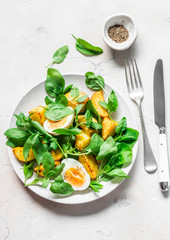 Baked potato, boiled egg and spinach salad on light background, top view