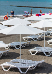 Sun beds with umbrellas on a pebble beach