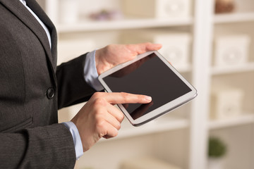 Business woman below chest using tablet in a homey environment