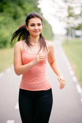 Sport, fitness, healthy lifestyle, cardio training. Active woman with athletic body running in the park. Smiling female jogger working out outdoor