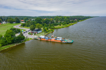 Fototapeta premium Aerial view of ferry at the Vistula river mouth to the Baltic sea. Poland. Photo made by drone from above. Bird eye view.