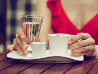 Woman in red dress drinking coffee in oriental Turkish style.