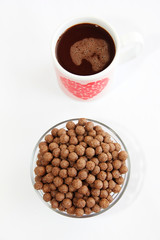 chocolate corn balls in a glass plate and cocoa mug for breakfast