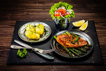 Grilled chicken fillet and vegetables on stone plate