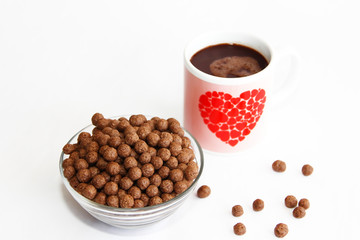 chocolate corn balls in a glass plate and cocoa mug for breakfast
