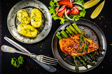 Grilled chicken fillet and vegetables on stone plate