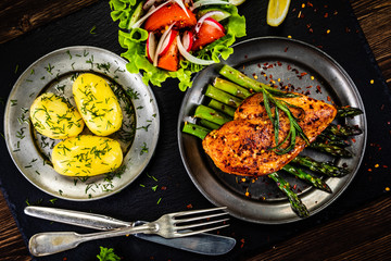 Grilled chicken fillet and vegetables on stone plate
