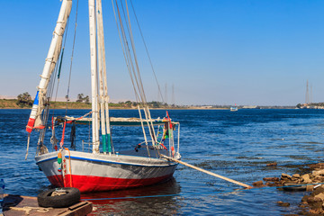 Felucca boat moored near the shore of Nile river in Luxor, Egypt