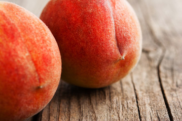 two peach fruits on old weathered wooden table background