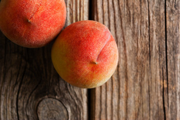 two peach fruits on old weathered wooden table background