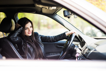 Beautiful young woman in the nice car is going to vacation.