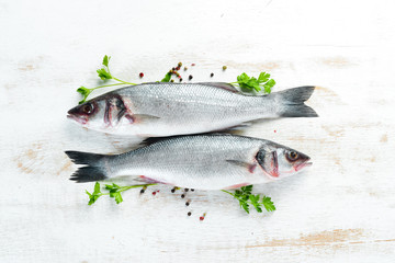 fish seabass with spices. Seafood on a white wooden background. Top view. Free copy space.