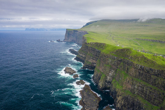 Aerial view of Mykines island in Faroe Islands, North Atlantic Ocean. Photo made by drone from above. Nordic natural landscape.